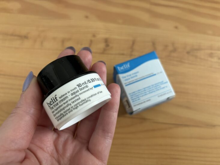 person holding sample of Belif moisturizer