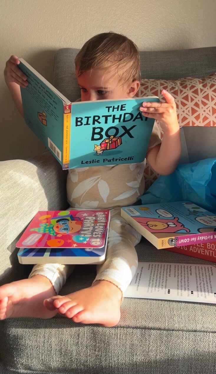 Kathryn's daughter reading her birthday-themed books from her latest StoryCaptain box.