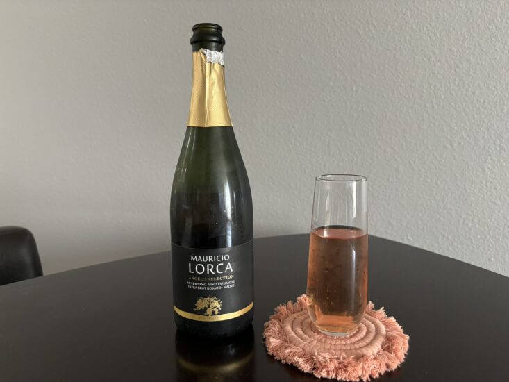 glass of sparkling rose wine in glass next to bottle