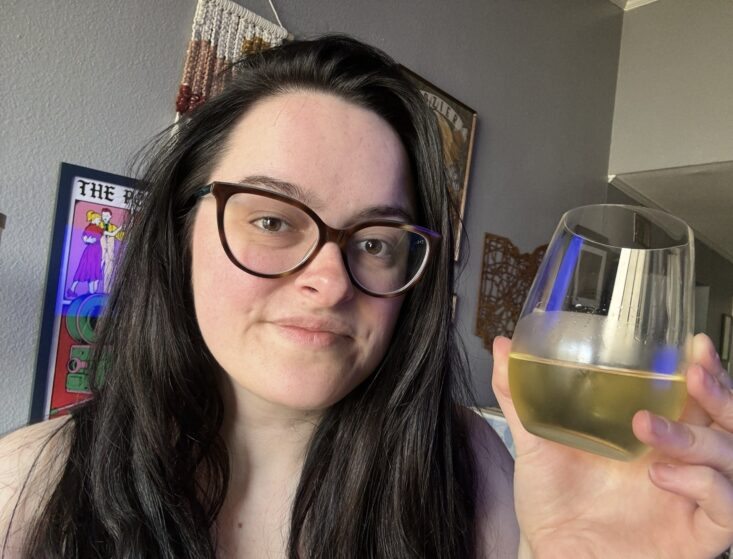 person holding up glass of sauvignon blanc wine