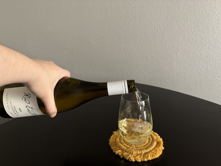 pouring of sauvignon blanc into wine glass on table