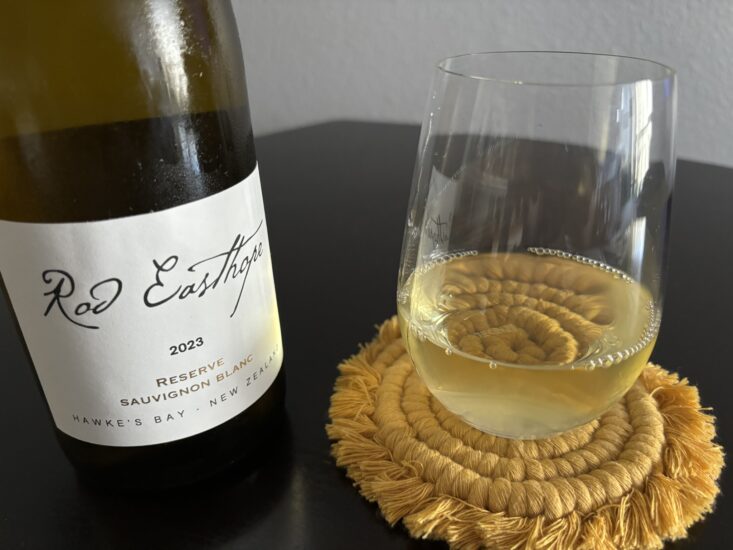 close up of bottle of sauvignon blanc next to wine glass on table