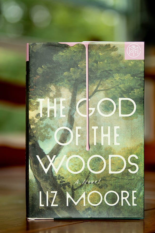 Book cover of The God of the Woods by Liz Moore with a Book of the Month Club logo in the corner