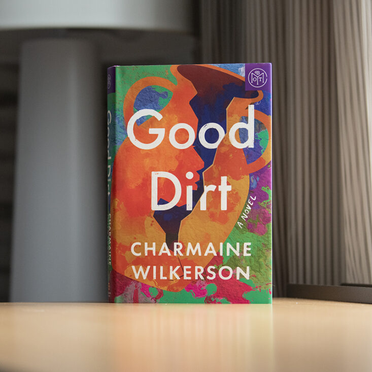 Good Dirt by Charmaine Wilkerson sits on a table. The book has a Book of the Month logo in the corner. 